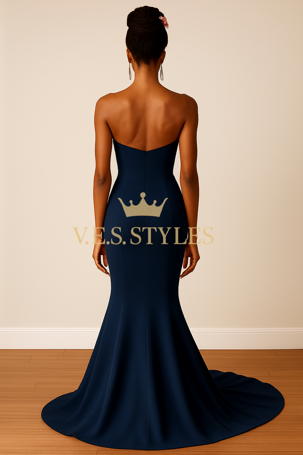 Navy blue evening gown with a crown design on the back, worn by a model against a beige wall.– V.E.S. Styles