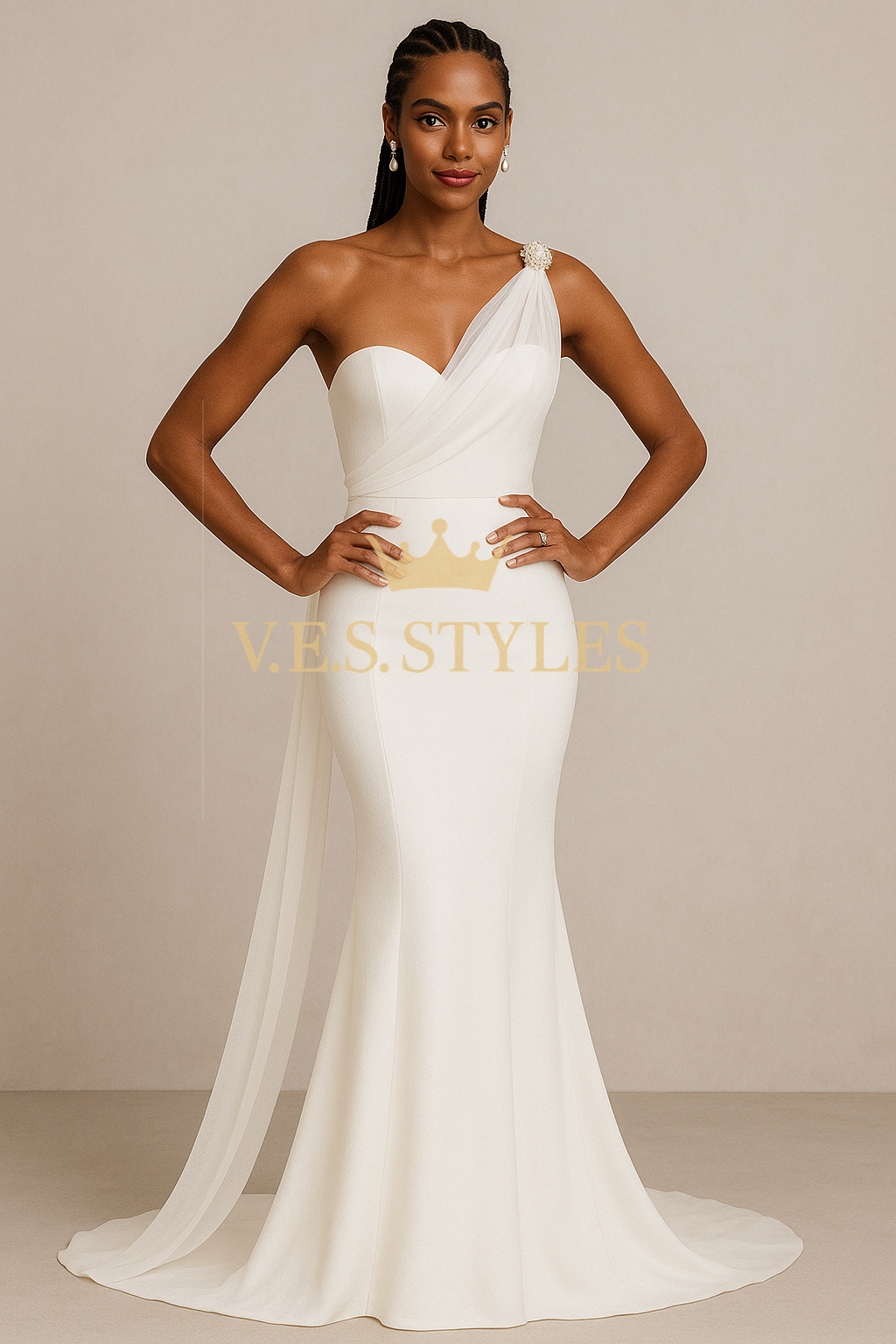 Woman wearing a white one-shoulder gown with a crown detail, standing against a beige background. – V.E.S. Styles